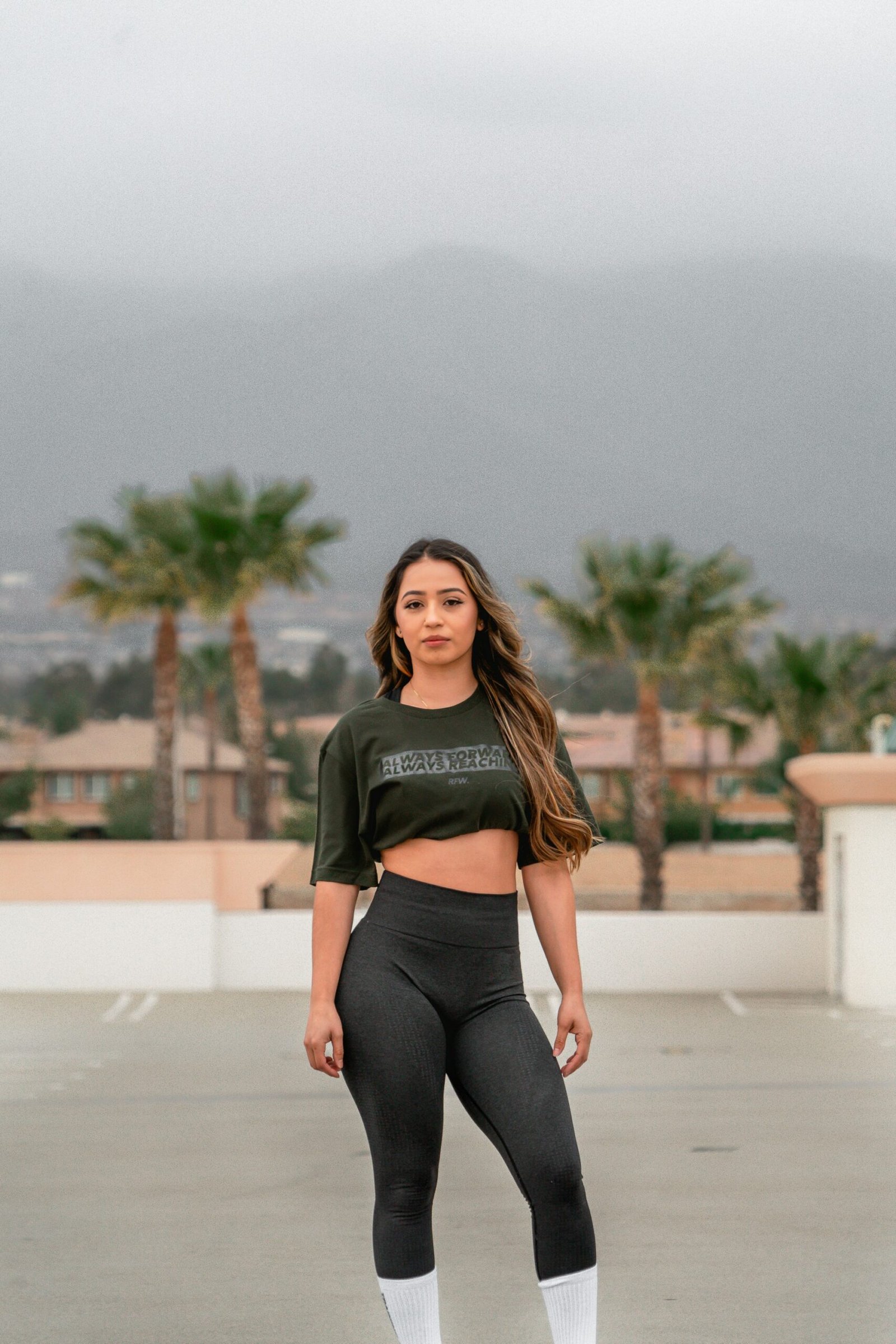 woman in gray and black long sleeve shirt and black leggings sitting on white concrete bench